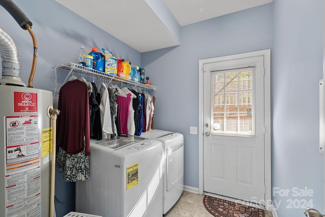 washroom with washer and dryer, light tile patterned floors, and gas water heater