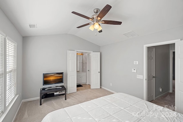 bedroom with ceiling fan, carpet flooring, lofted ceiling, and ensuite bathroom