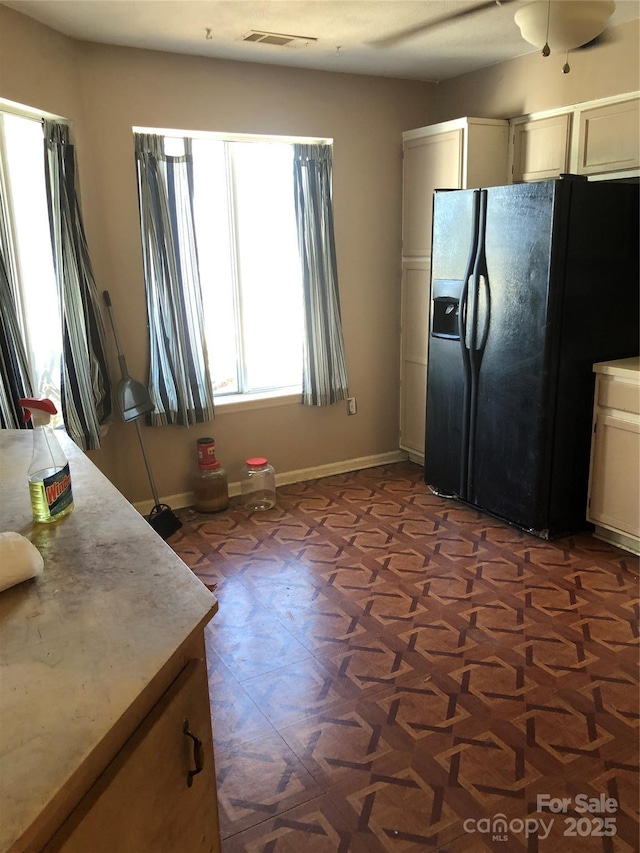 kitchen with black refrigerator with ice dispenser