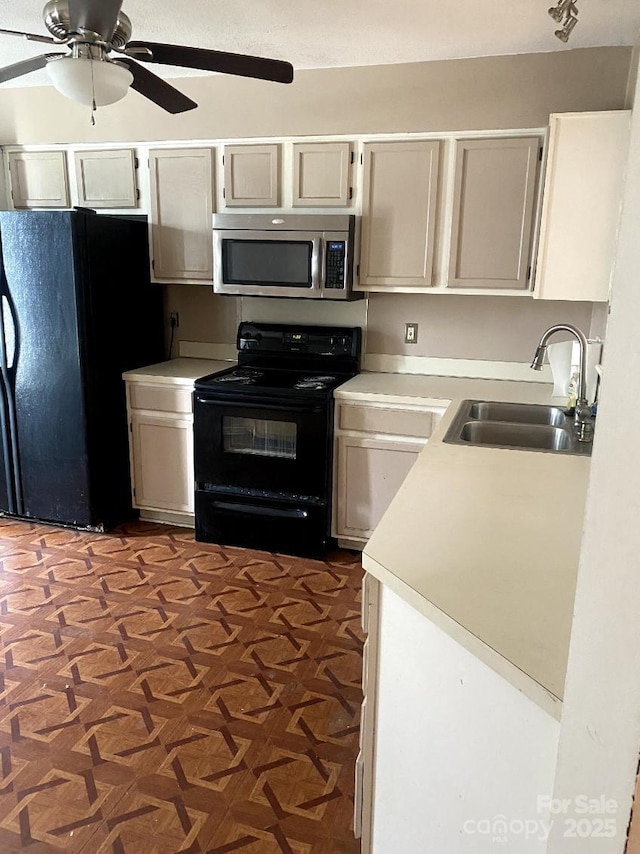 kitchen with dark parquet flooring, sink, ceiling fan, and black appliances