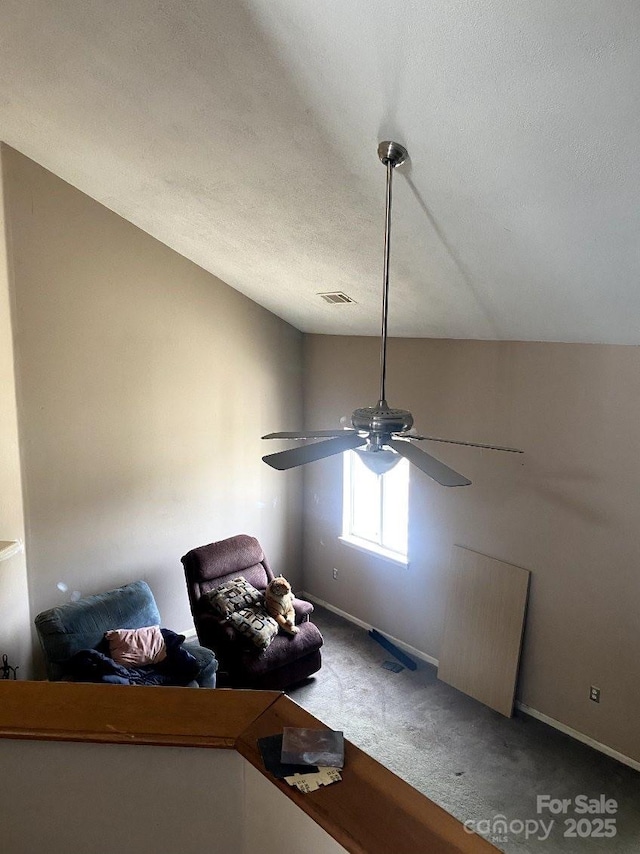 interior space with ceiling fan, a textured ceiling, and carpet flooring