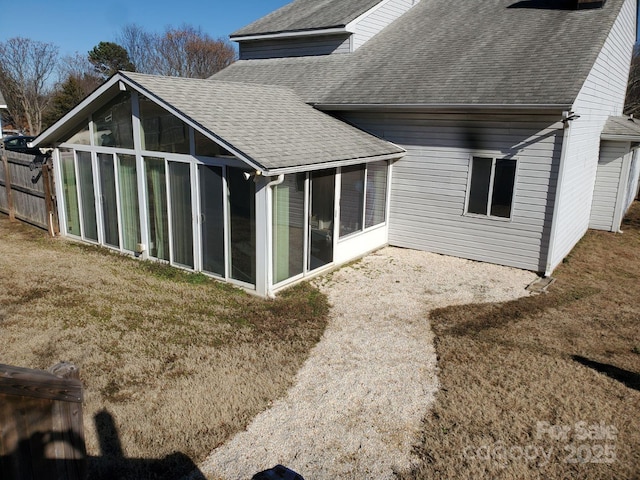 back of house with a sunroom and a yard