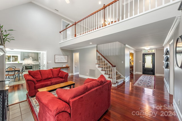 living room with ornamental molding, a high ceiling, and dark hardwood / wood-style flooring