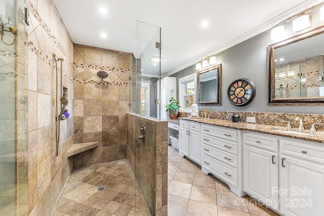 bathroom with vanity, a tile shower, ornamental molding, and tile patterned floors