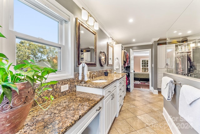 bathroom featuring vanity, backsplash, tile patterned floors, and ornamental molding