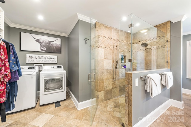 bathroom featuring a shower with door, crown molding, and separate washer and dryer