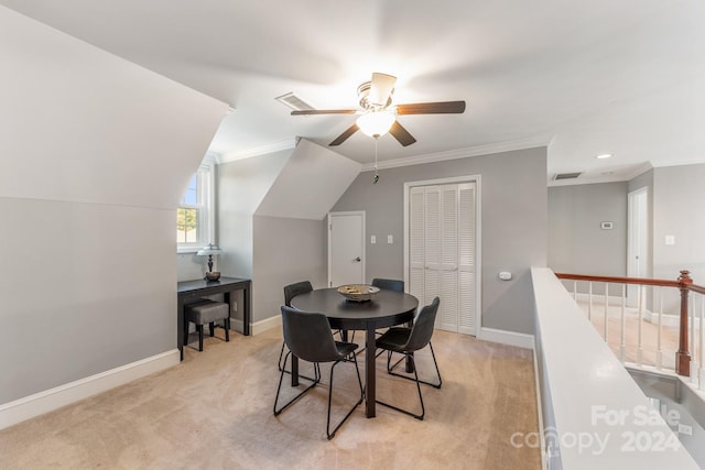 dining space with ornamental molding, vaulted ceiling, light carpet, and ceiling fan