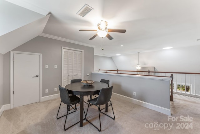 carpeted dining area with lofted ceiling, ornamental molding, and ceiling fan