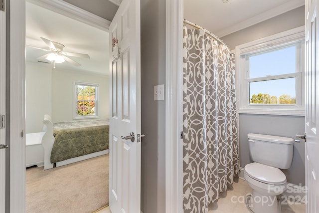 bathroom with toilet, crown molding, curtained shower, and ceiling fan