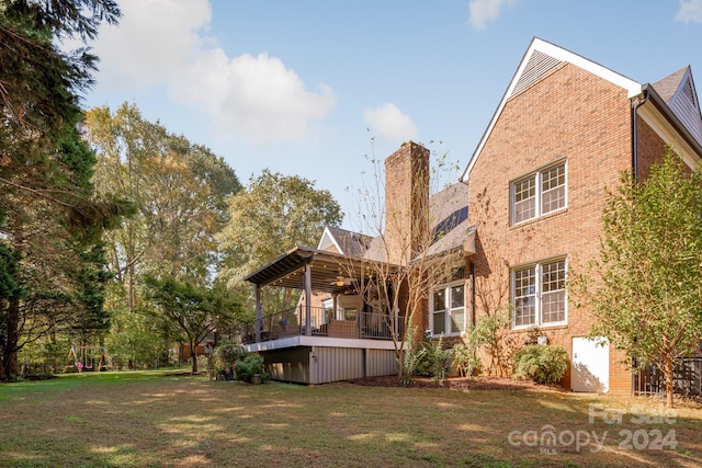 rear view of house featuring a wooden deck and a yard