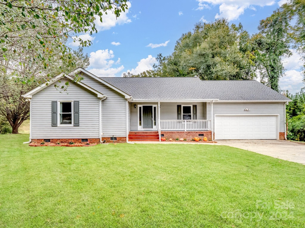 single story home featuring a front yard, a porch, and a garage