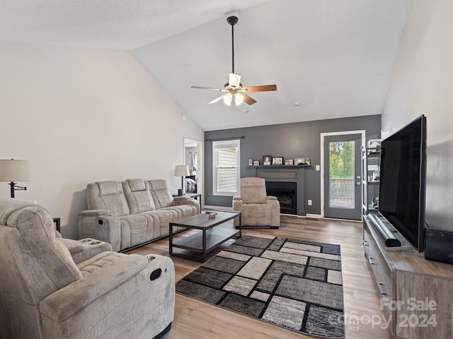 living room with light hardwood / wood-style floors, high vaulted ceiling, and ceiling fan