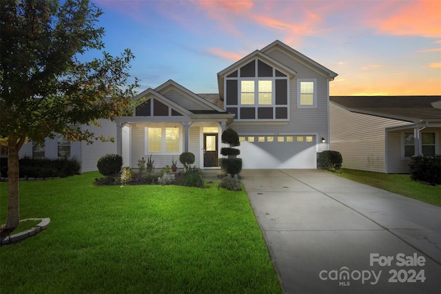 view of front of house featuring a garage and a lawn