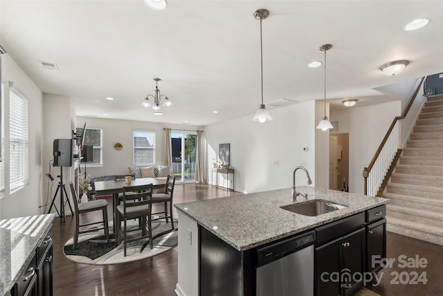 kitchen featuring stainless steel dishwasher, sink, an island with sink, and pendant lighting