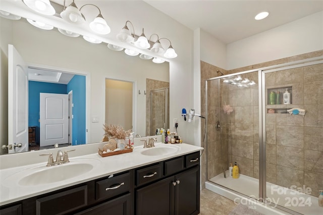 bathroom with a shower with door, tile patterned flooring, and vanity