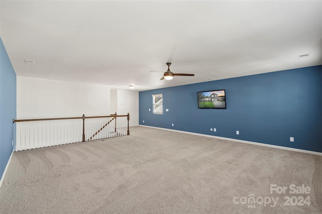 carpeted spare room featuring ceiling fan