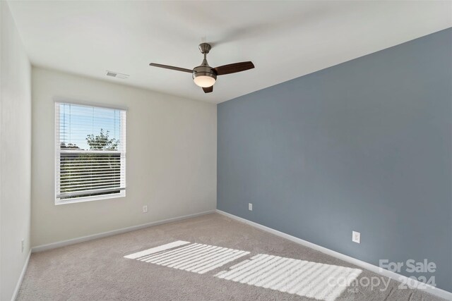 unfurnished room featuring light colored carpet and ceiling fan