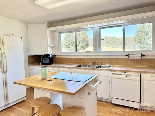 kitchen with white cabinets, white appliances, a healthy amount of sunlight, and sink