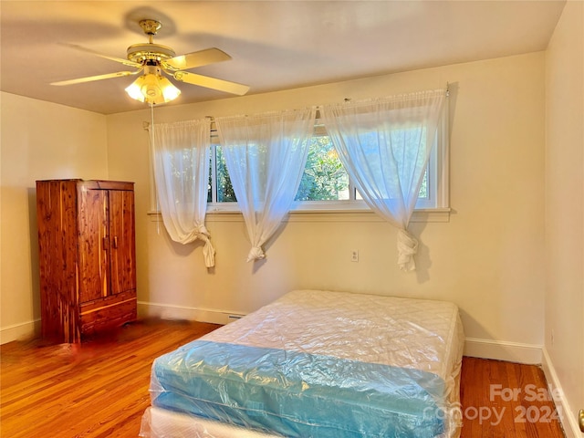 bedroom with ceiling fan and hardwood / wood-style flooring