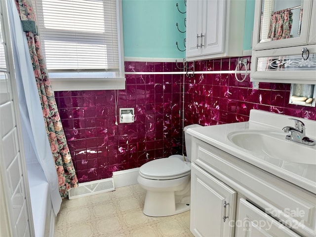 full bathroom featuring vanity, toilet, tile walls, and shower / bath combo with shower curtain