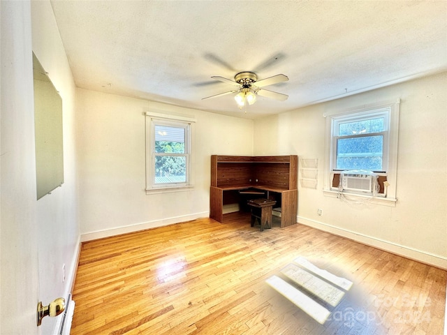 living room featuring a textured ceiling, light hardwood / wood-style floors, cooling unit, and ceiling fan