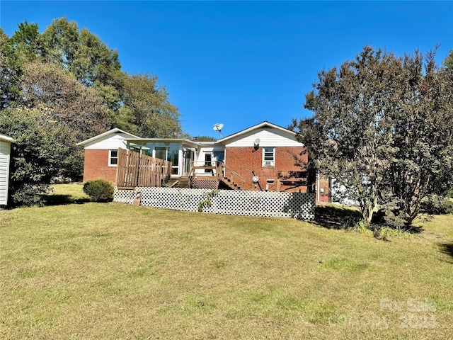 rear view of house featuring a deck and a yard