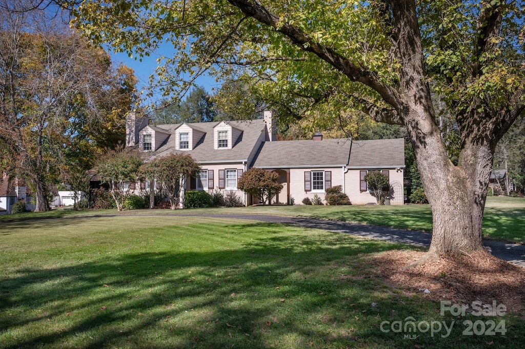 new england style home featuring a front yard