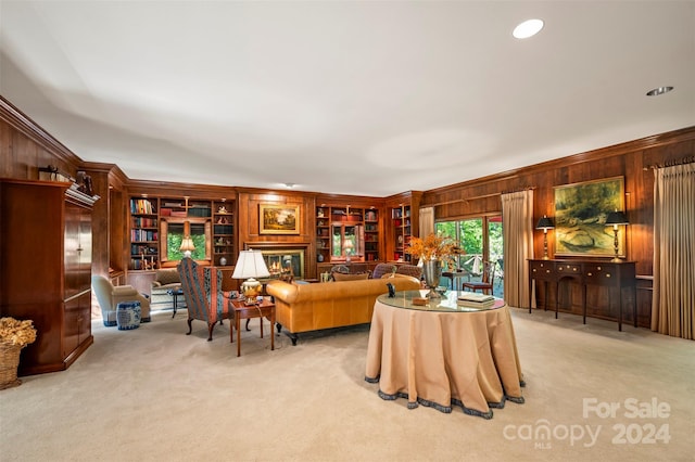 carpeted living room featuring ornamental molding, wood walls, and built in features