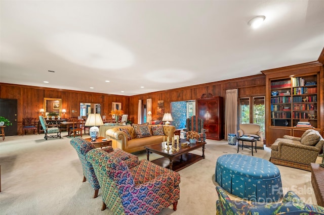 living room with crown molding, wood walls, and light colored carpet