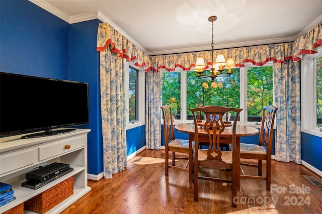 dining space featuring crown molding, wood-type flooring, a chandelier, and plenty of natural light