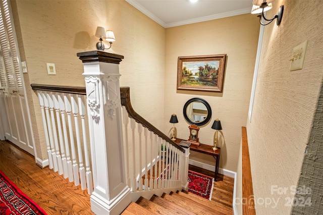 staircase with ornamental molding and hardwood / wood-style flooring