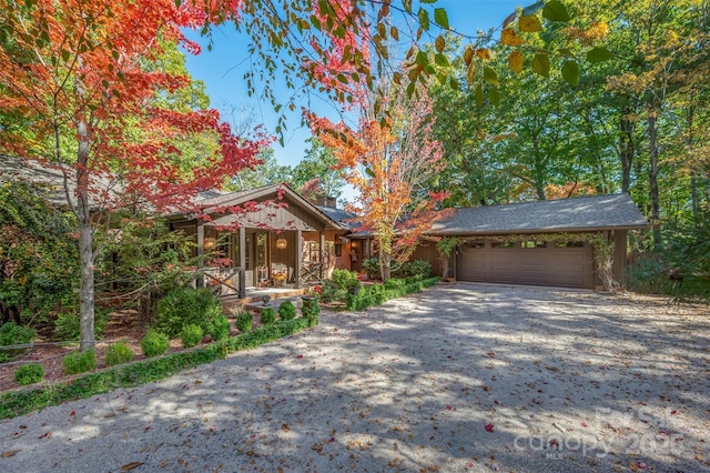 view of front of house with driveway, a chimney, and an attached garage