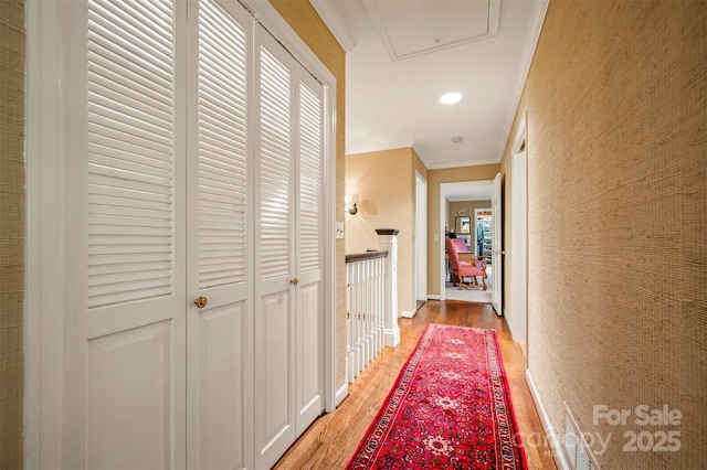 hallway with recessed lighting, light wood-type flooring, an upstairs landing, and ornamental molding