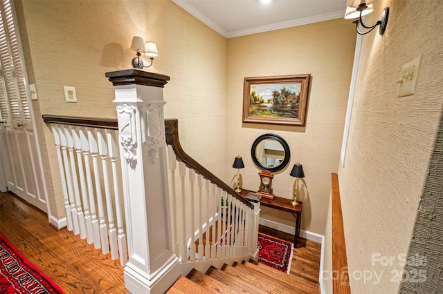 stairs with crown molding, baseboards, and wood finished floors