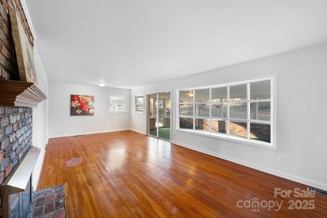 unfurnished living room with a fireplace and wood-type flooring