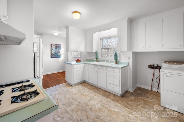 kitchen featuring gas stovetop, sink, white refrigerator, white cabinets, and washer / clothes dryer