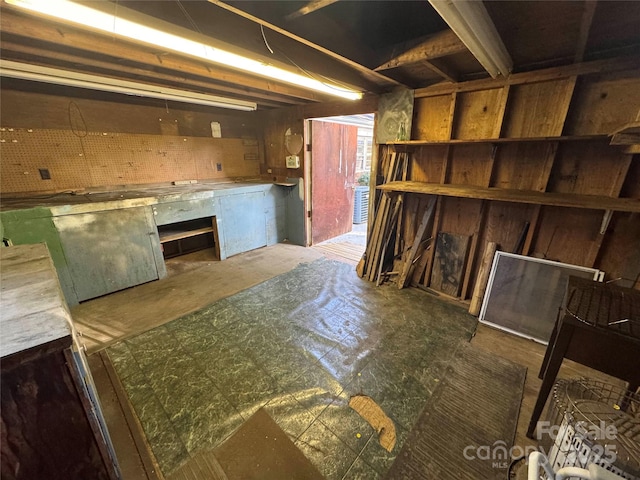 basement featuring a workshop area and wood walls