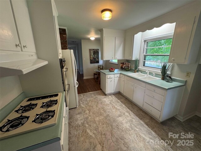 1727 Hartford Dr, Gastonia, NC 28052 - kitchen with a sink, range, white cabinets, baseboards, and light countertops