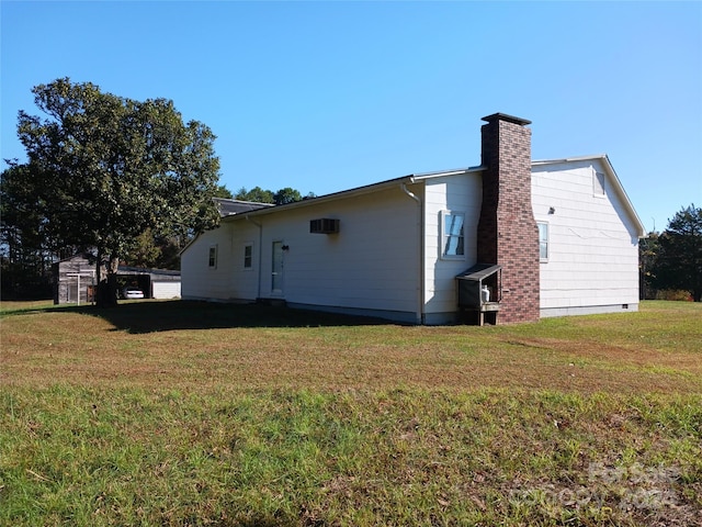 view of home's exterior featuring a lawn and a storage shed