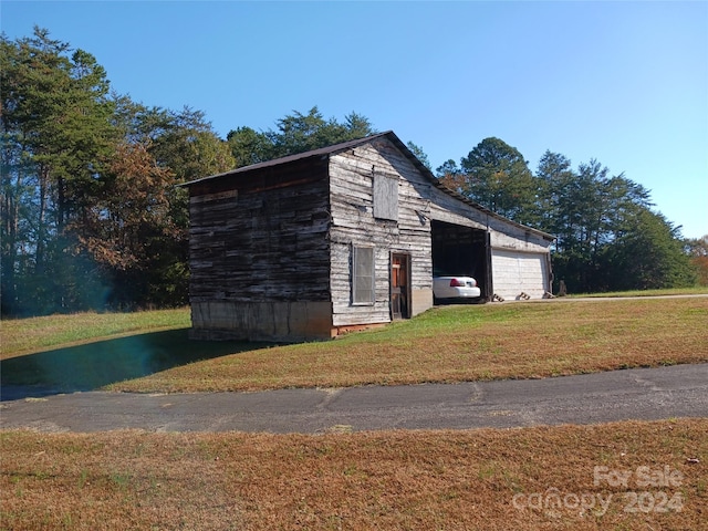 view of outdoor structure with a lawn and a garage