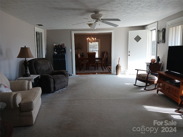 carpeted living room featuring ceiling fan with notable chandelier and a textured ceiling