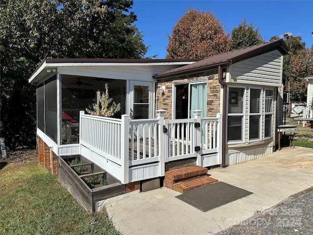 rear view of property featuring a sunroom and a patio area