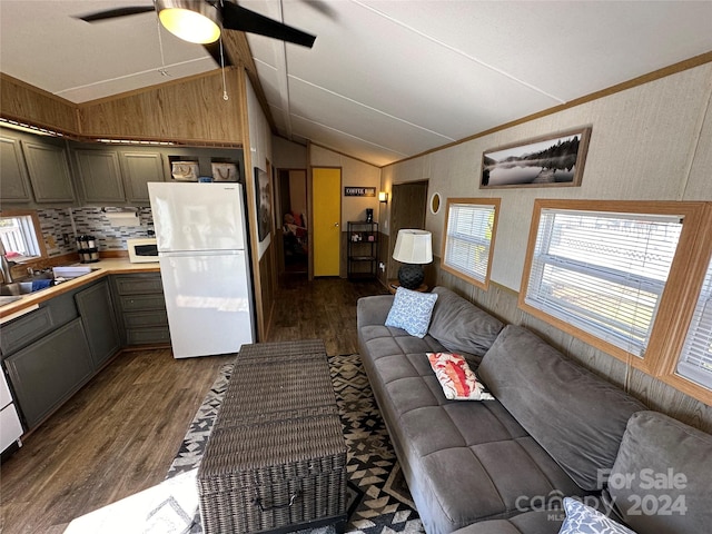 living room with dark hardwood / wood-style flooring, sink, ceiling fan, and vaulted ceiling