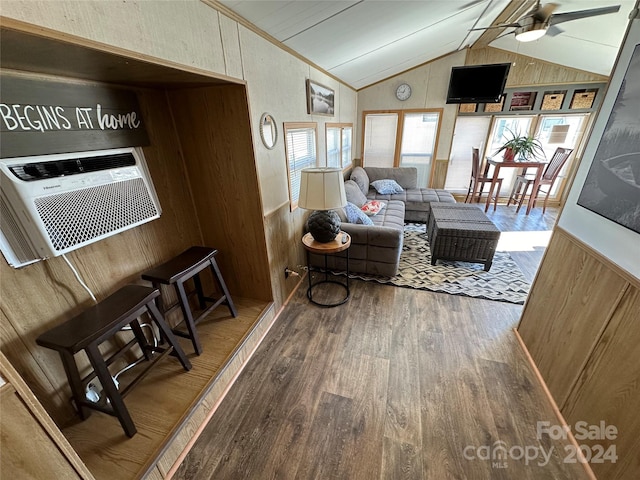 living room with wood walls, hardwood / wood-style flooring, ceiling fan, and lofted ceiling