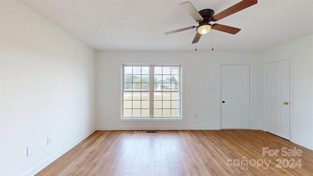 empty room featuring ceiling fan, a textured ceiling, and light wood-type flooring