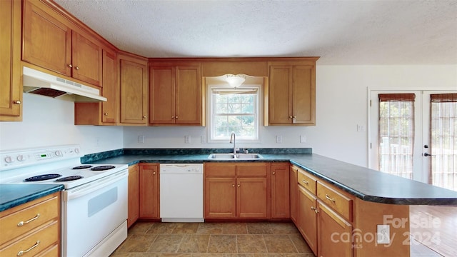 kitchen with kitchen peninsula, a textured ceiling, sink, and white appliances