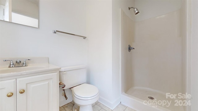 bathroom featuring vanity, a shower, toilet, and tile patterned floors