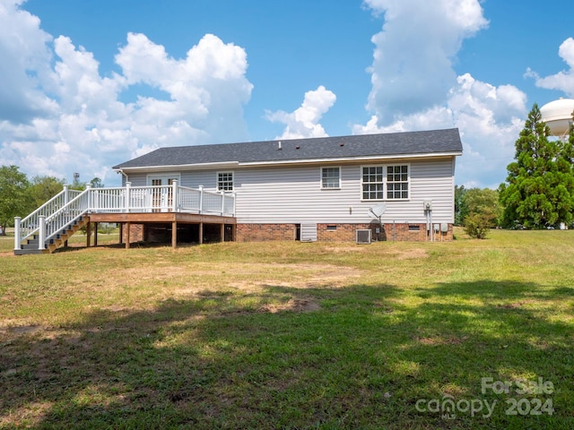 rear view of property featuring a deck and a yard