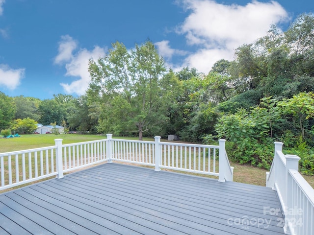 wooden deck featuring a lawn