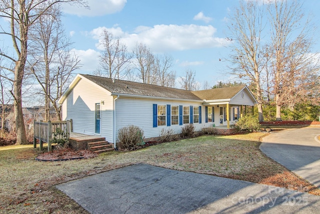 view of property exterior featuring a porch, a deck, and a lawn